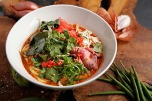 Delicious Thai noodle soup garnished with fresh herbs and slices of beef.